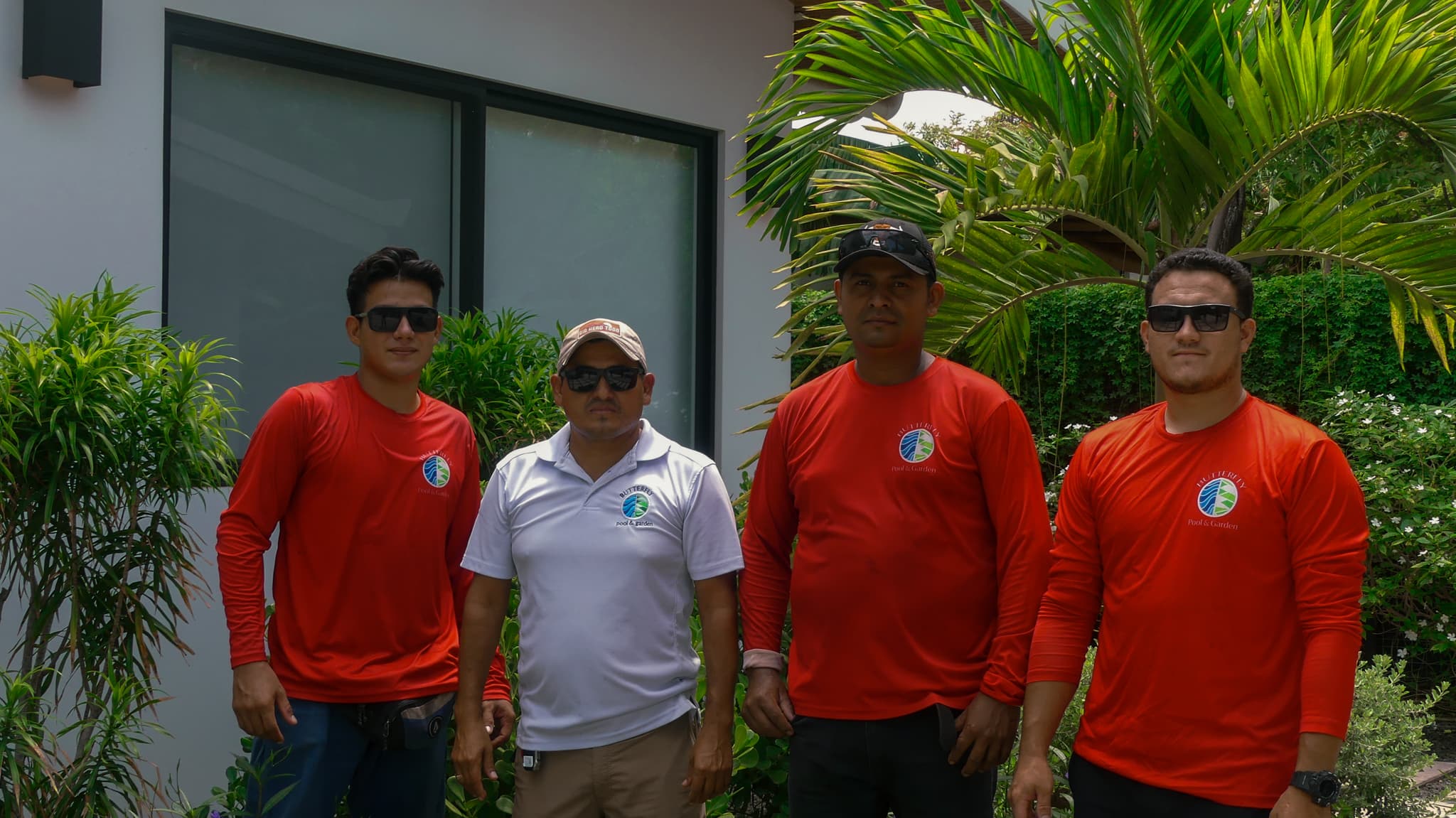 Cuatro integrantes del equipo de Butterfly Pool & Garden en una propiedad.